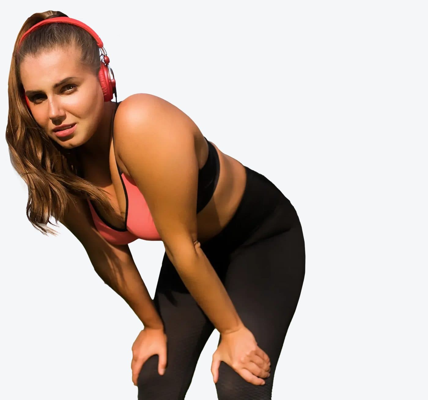 Studio portrait of a woman in athletic wear with red headphones, mid-workout